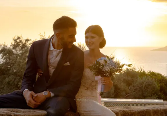 Fotografo di matrimonio in Sicilia ritrae gli sposi al tramonto con il mare di Sciacca sullo sfondo dopo la cerimonia, in un momento romantico e spontaneo.