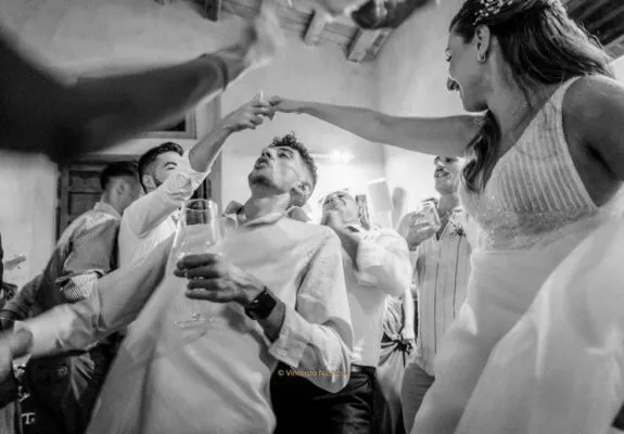 La sposa mentre brinda e balla con gli amici durante il ricevimento, raccontando un momento spontaneo, dinamico e ricco di emozioni.