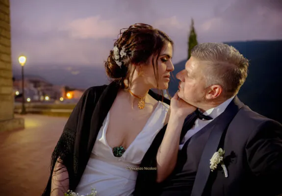 Fotografo di matrimonio in Sicilia realizza un ritratto degli sposi al crepuscolo nel borgo di Curinga, in Calabria, dopo la cerimonia, con uno sfondo romantico e un momento di autentica complicità.